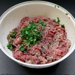 In una ciotola, unite il macinato di carne, il parmigiano grattugiato e il prezzemolo tritato