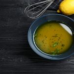 Ciotola con vinaigrette con limoni su sfondo nero