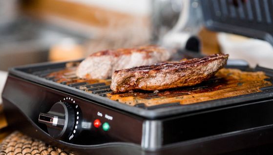 Carne in cottura sulla bistecchiera elettrica
