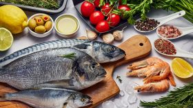 tagliere con diversi tipi di pesce e alimenti vegetali
