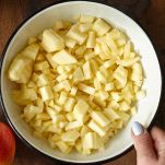 In una ciotola ampia, unite le mele con tutti gli altri ingredienti per il ripieno, tranne il burro e il pangrattato.