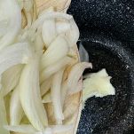 Versate in una pentola a bordi alti il pezzetto di burro e, appena sciolto, aggiungete la cipolla tagliata precedentemente a fettine sottili