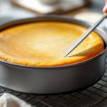 Cheesecake appena cotta con coltello passato sul bordo
