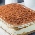 Pareggiate l'ultimo strato di crema, pulite i bordi della pirofila e riponete in frigorifero per almeno 3 ore; spolverate con cacao amaro solo prima di servire