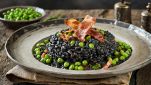 Il Risotto al nero di seppia con piselli e pancetta croccante