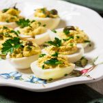 Uova sode ripiene di tonno e capperi impiattate e decorate