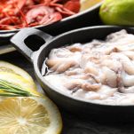Calamari crudi messi a marinare all’interno di una ciotola capiente
