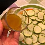 Emulsione olio e limone con zucchine sullo sfondo