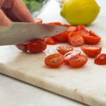Tagliare i pomodorini su un tagliere