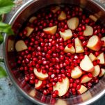 Chicchi di melagrana e pezzi di mela in pentola