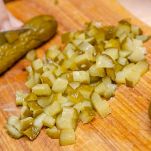 Tagliate i cetriolini sott’aceto a cubetti molto piccoli