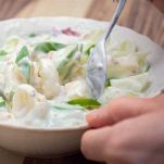 Versate l'emulsione preparata sopra l’insalata e mescolate delicatamente per distribuire uniformemente il condimento.