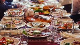 gruppo di persone a un lungo tavolo con il cibo