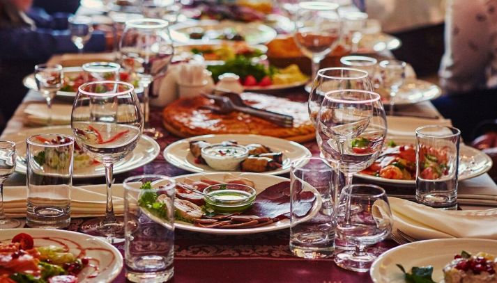 gruppo di persone a un lungo tavolo con il cibo