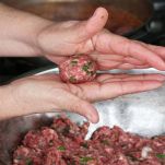 Cooking Moroccan meatballs in tomato sauce forming a meatball