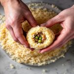 Riso modellato a sfera con ripieno di carne e piselli al centro