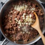 Carne macinata in cottura con cipolle in casseruola.