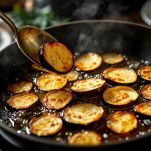 Melanzane fritte dorate su carta assorbente.