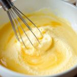 Ciotola con tuorli montati con frusta a mano.