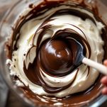 Mani che incorporano albumi e tuorli montati nel composto di cioccolato.