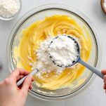 Ingredienti secchi aggiunti al composto liquido in ciotola.