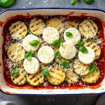 Teglia con strati di zucchine, pomodoro e mozzarella.