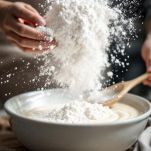 Farina aggiunta in ciotola con composto di uova e zucchero.