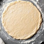 Impasto steso con mattarello e stampi per biscotti.