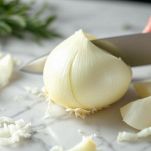 Cipolla tagliata a spicchi su tagliere.