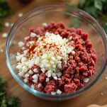 Carne macinata con cipolla e spezie in ciotola.