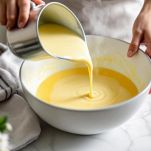 Panna versata in ciotola con tuorli montati.