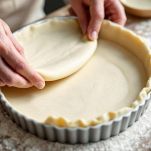 Pasta frolla stesa in teglia rotonda.
