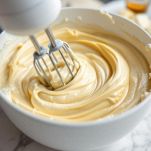 Burro, zucchero e vaniglia montati in ciotola con fruste elettriche.
