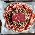 Filetto avvolto in prosciutto crudo e crema di funghi su pellicola.