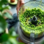 Piselli pestati con olio e spezie in ciotola di vetro.