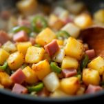 Patate e prosciutto cotto saltati in padella con verdure.