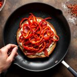 Strisce di peperone rosso fresco su tagliere.