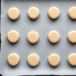 Dischetti di impasto per macaron su teglia prima della cottura.
