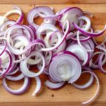 Cipolle di Tropea affettate su un tagliere.