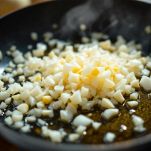 Cipolla e aglio che soffriggono in padella con olio.