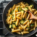 Pasta e zucchine mescolate in padella.