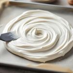 Meringa modellata con conca centrale sulla teglia.