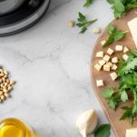 Ingredienti per pesto di rucola disposti nel frullatore.
