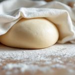 Impasto coperto che riposa sotto un panno.