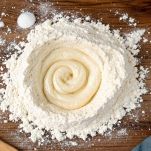 Farina a fontana con lievito al centro e sale esterno.
