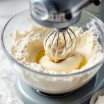 Planetaria con farina e liquidi versati a filo.