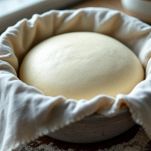 Impasto che lievita coperto nella ciotola.