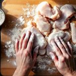 Pezzi di pollo infarinati pronti per la cottura.