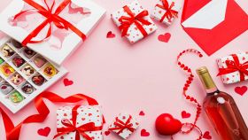 regali di san valentino su sfondo rosa con bottiglia di vino cioccolatini e decorazioni
