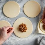 Dischi di impasto riempiti con ripieno speziato.